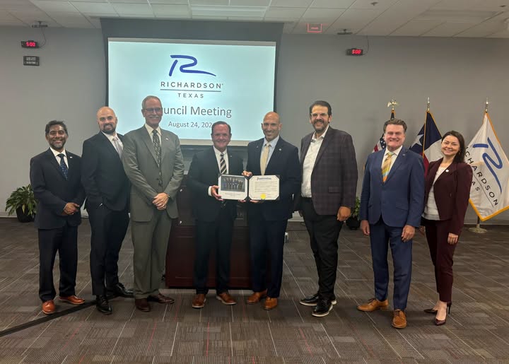 Photo shows the Richardson City Council with the Richardson City Manager in the middle. 
